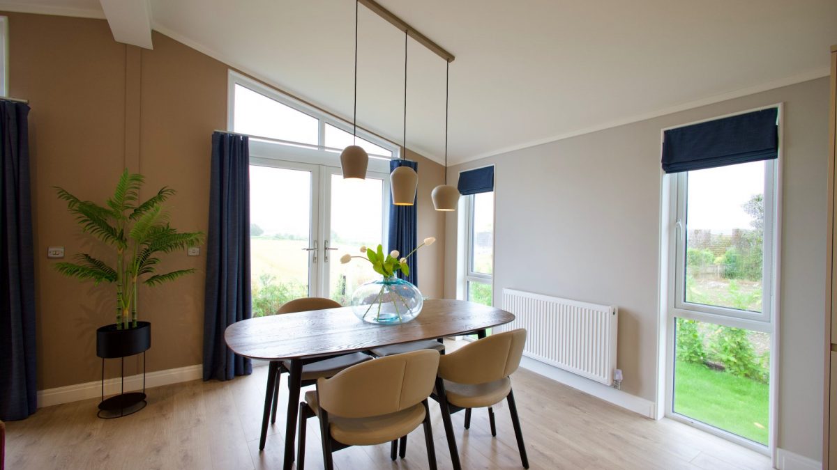 Dining table in the Lusso and Harbur park home overlooking open countryside fields