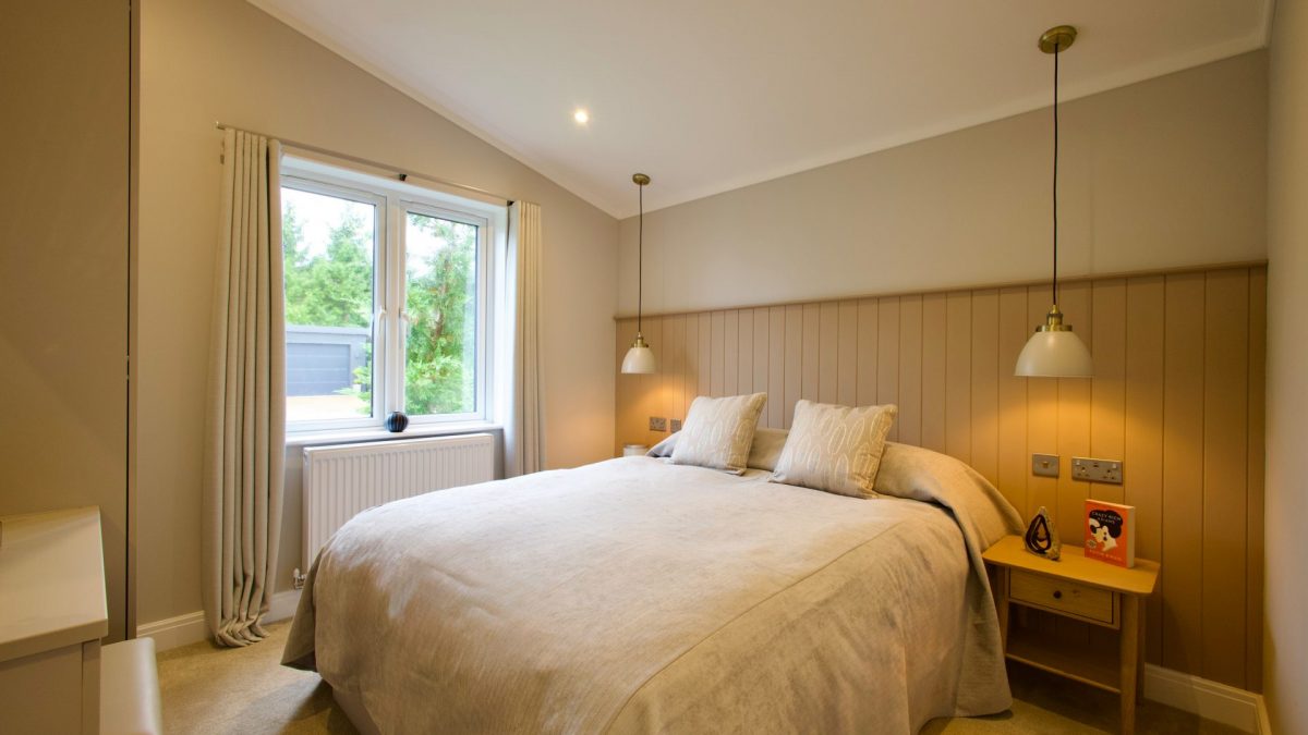Harbur H3 Bespoke park home guest bedroom with a double bed, two side tables and and two hanging lights, fully furnished